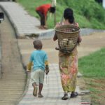 A woman and a child walking down a sidewalk