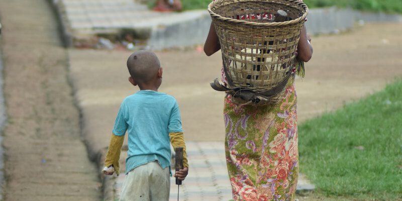A woman and a child walking down a sidewalk