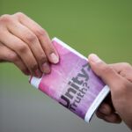 selective focus photography of two persons holding purple and white Unity truth? booklet