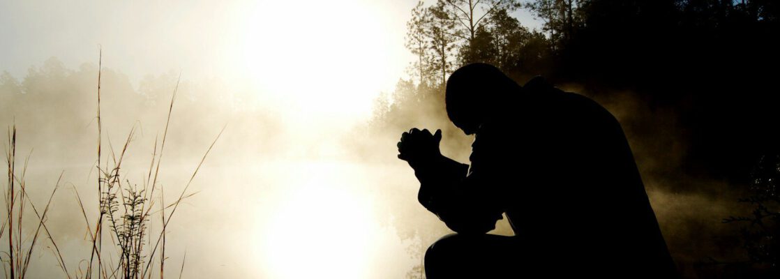 silhouette of kneeling man